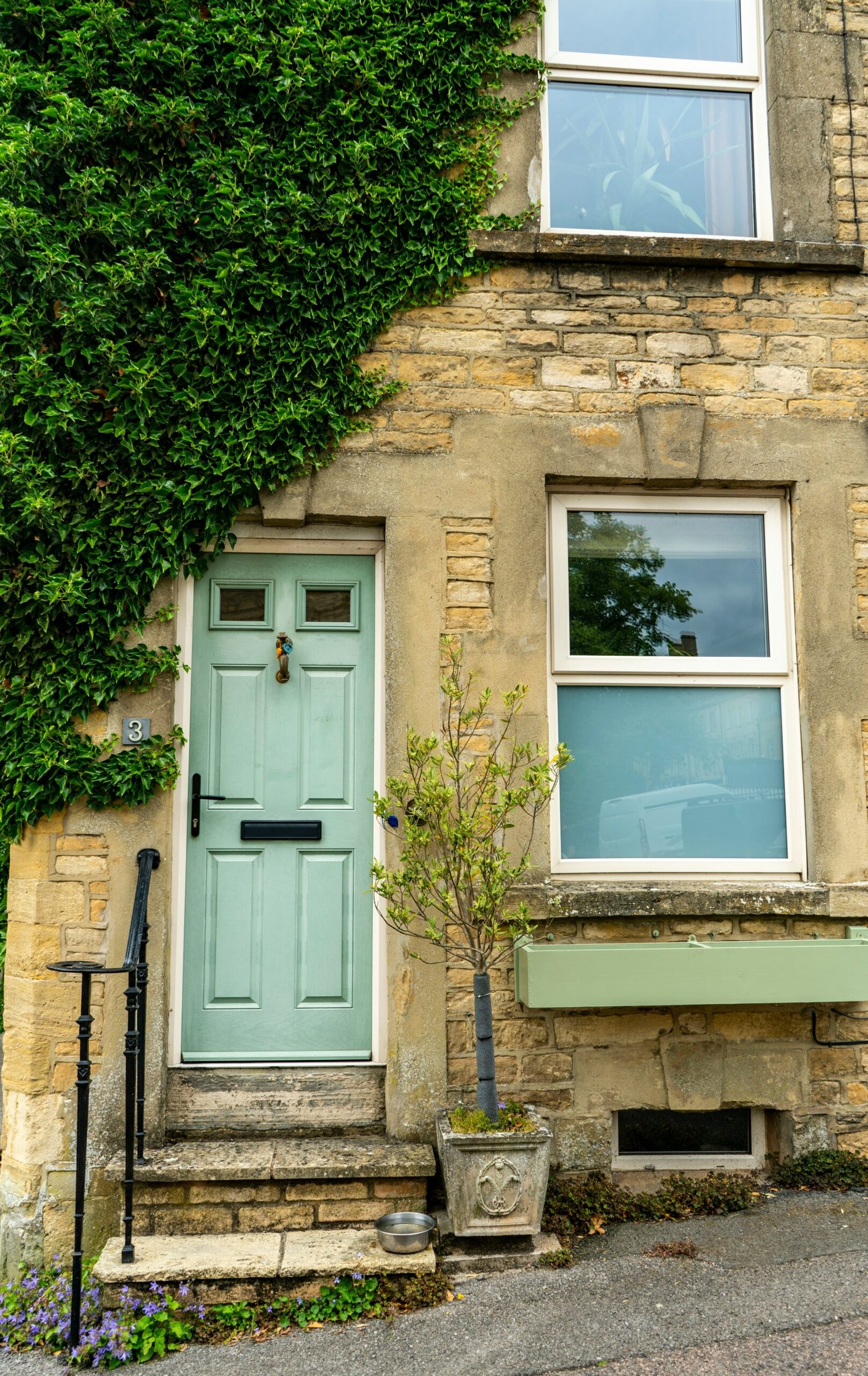 A stone cottage with a pale green front door